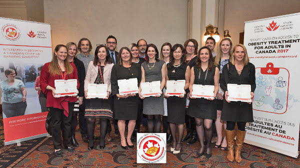 Groupe de professionnels titulaires de certificats, debout devant les bannières d'Obésité Canada lors d'un événement.