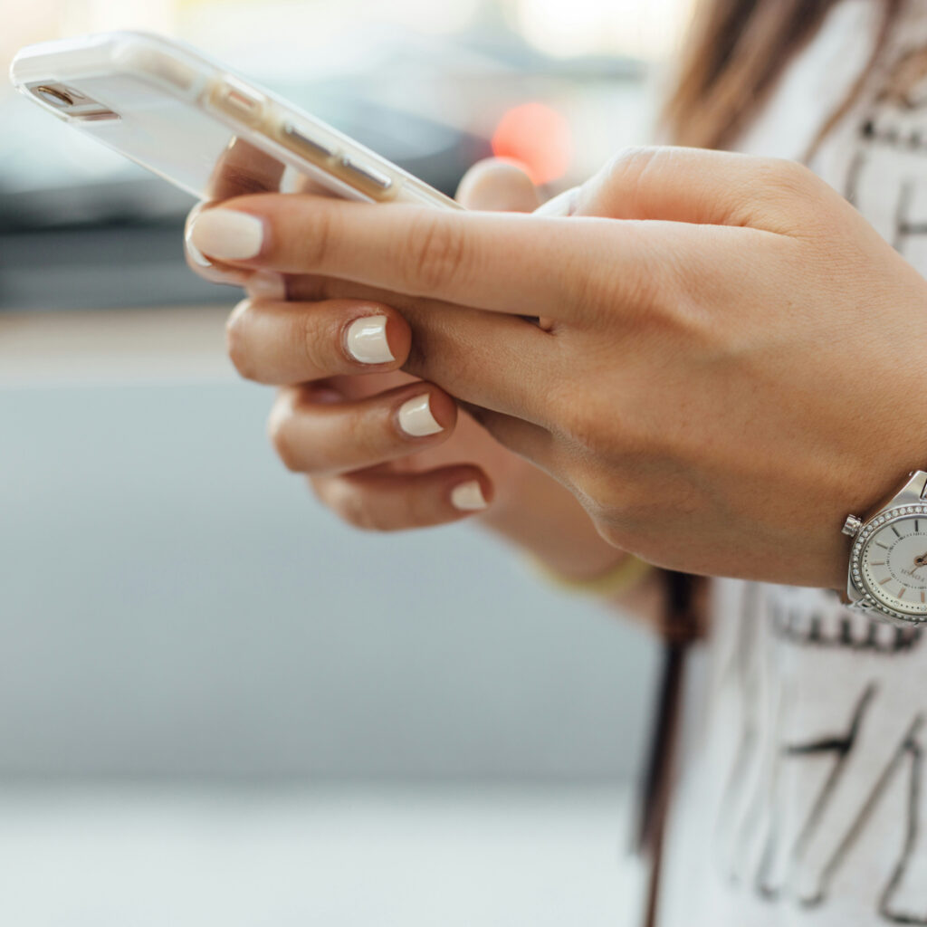 A closeup of a woman's hands holding a smartphone