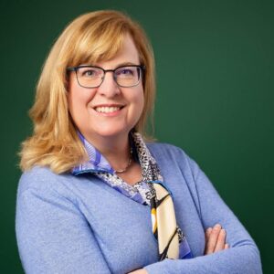 Dr. Denise Campbell Scherer smiling at the camera wearing a lavender blue blazer and scarf