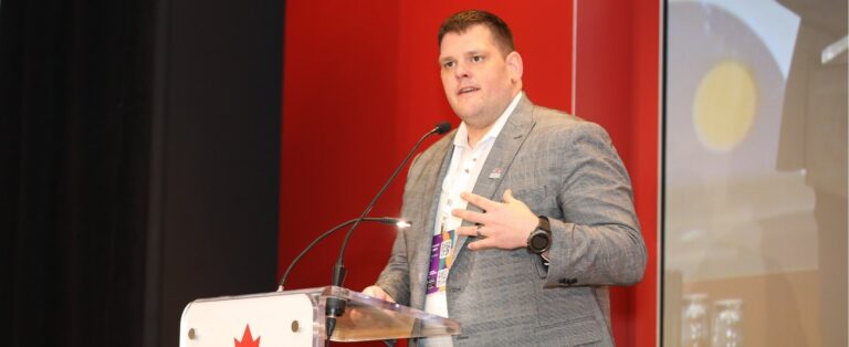 Dr. Ian Patton speaking on a stage with a red background and a podium that reads, Obesity Canada.